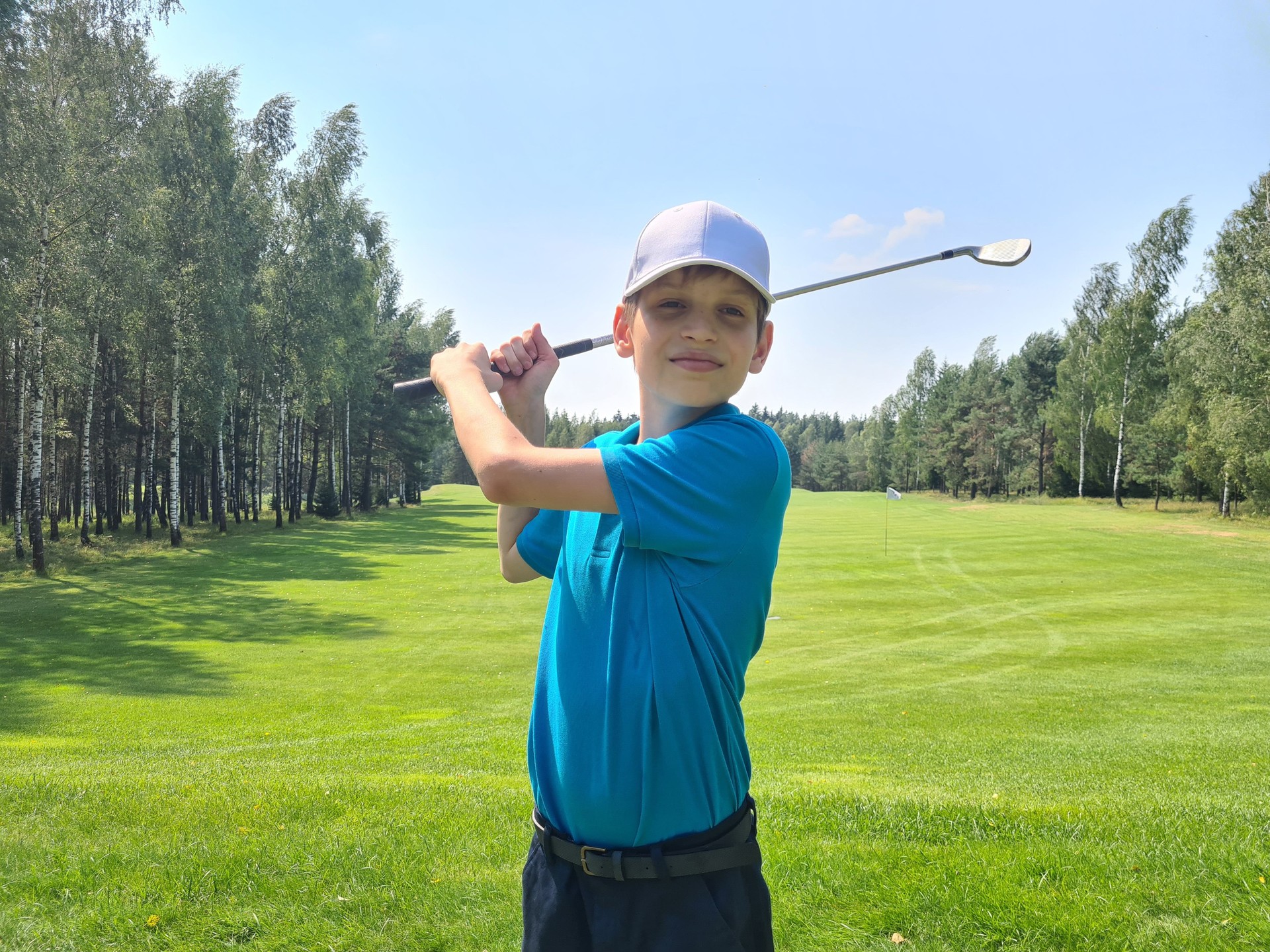 Teenage boy is swinging in golf club